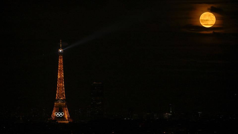  This photograph shows the Olympic rings displayed on the Eiffel Tower at night, with the full moon appearing, ahead of the Paris 2024 Olympic and Paralympic games, in Paris on July 21, 2024. 