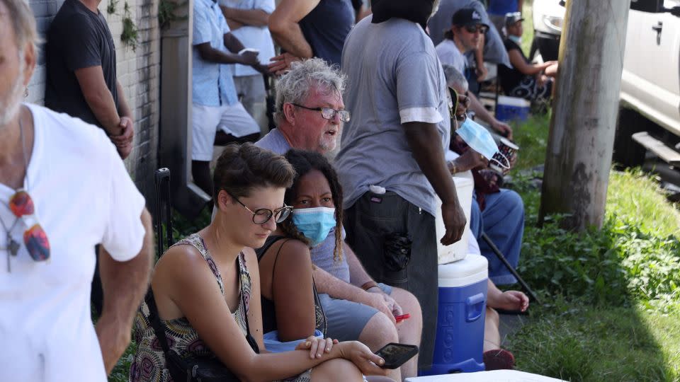 People waiting in extreme heat to buy ice at Duplantier Ice Service in New Orleans, Louisiana on September 1, 2021, as power remained out in most of the city after Hurricane Ida ripped through the state. - Leah Millis/Reuters