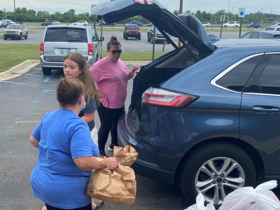 Jefferson volunteers load up the car with meal packs.