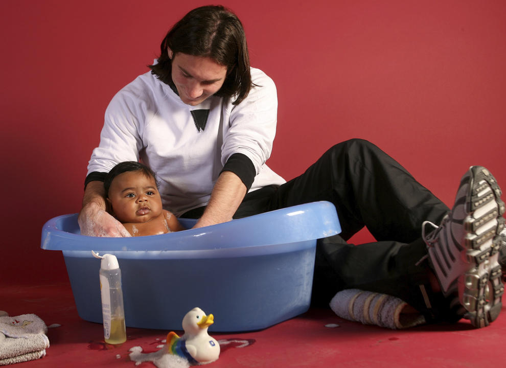 This photo taken in Sept. 2007 shows a 20-year-old Lionel Messi, who had embarked on his legendary Barcelona career just over four years prior, helping to bathe Lamine Yamal, who was merely six months old at the time during a photo session in the dressing room of the Camp Nou stadium in Barcelona, Spain. Lamine Yamal is now a soccer sensation for both Spain and Barcelona and he is still only 16-years-old. (AP Photo/Joan Monfort)