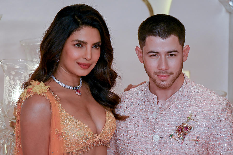 Bollywood actress Priyanka Chopra and singer Nick Jonas at the wedding ceremony in glittering outfits.