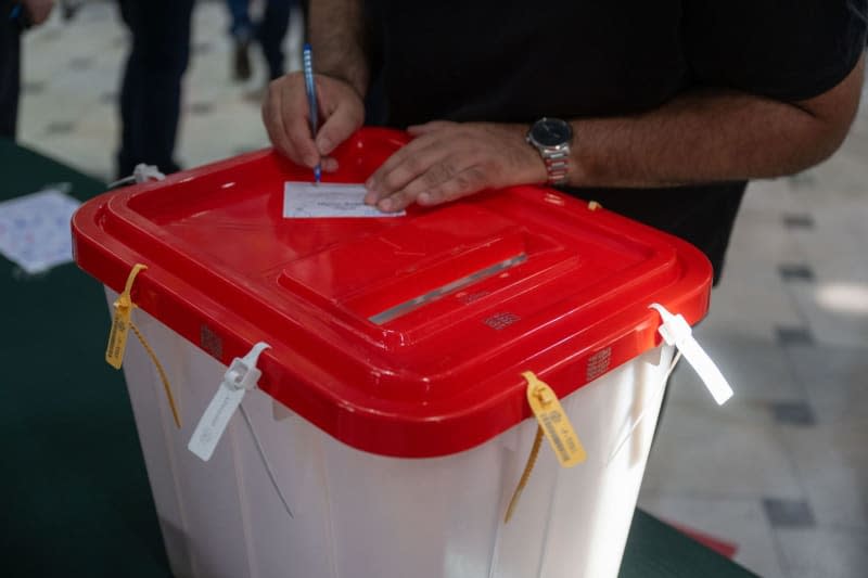 A man fills out his ballot paper at a polling station during the run-off election for the Iranian presidential elections. Arne Bänsch/dpa