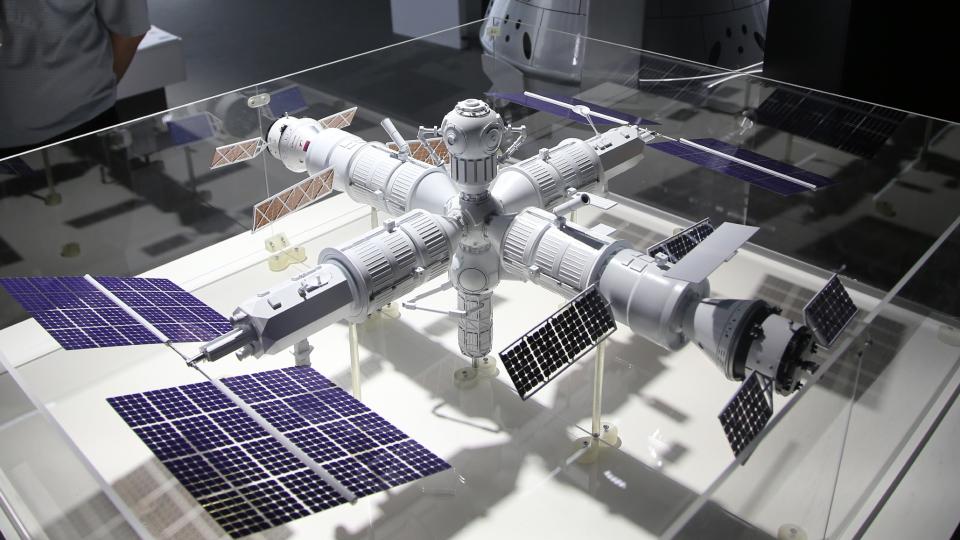  A model of a cross-shaped space station in a glass case in a museum . 