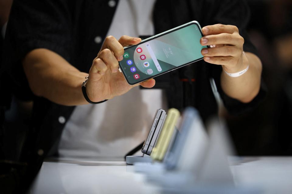 An attendee tries out a Samsung Electronics' Galaxy Z Flip 6 during its unveiling ceremony in Seoul, South Korea, July 8, 2024. REUTERS/Kim Hong-Ji