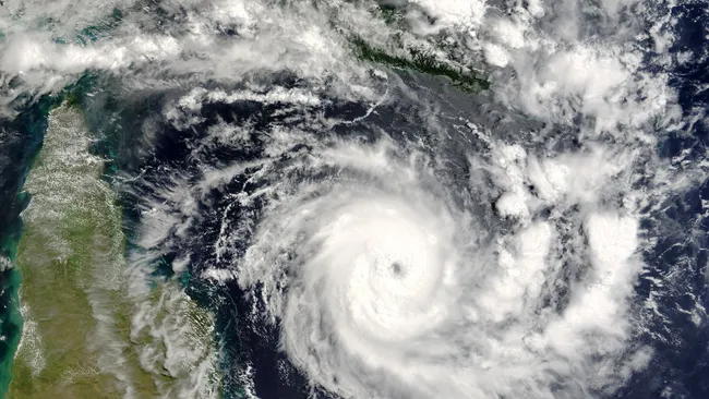  A satellite photo of clouds over land and ocean. 