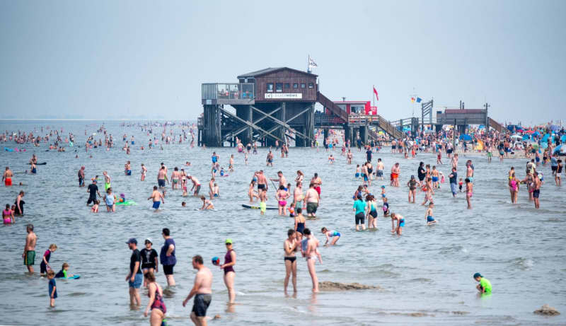 Numerous tourists bathe in the North Sea in the sunshine. Daniel Bockwoldt/dpa