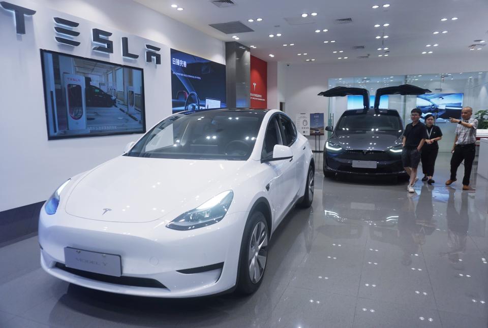 HANGZHOU, CHINA - AUGUST 14, 2023 - Customers buy electric cars at a Tesla store in Hangzhou, East China's Zhejiang province, Aug. 14, 2023. On the same day, Tesla announced that it had lowered the price of its two high-end Model Y models in the Chinese market, reducing the price of each car by $1,900 (about 14,000 yuan), and also announced an 8,000 yuan limited time insurance subsidy for existing Model 3 car orders. (Photo credit should read CFOTO/Future Publishing via Getty Images)