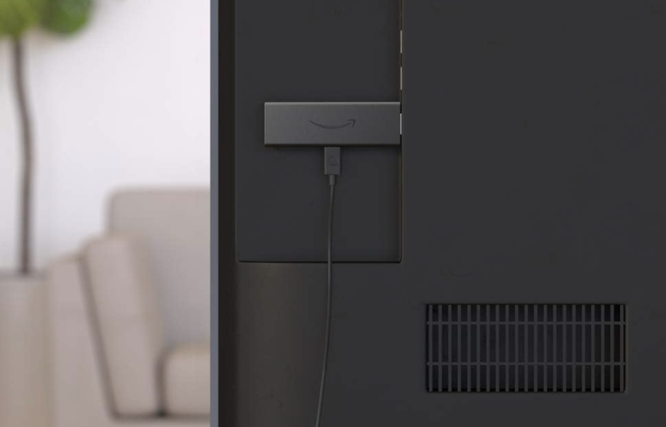 The Amazon Fire TV Stick plugged into the back of a TV