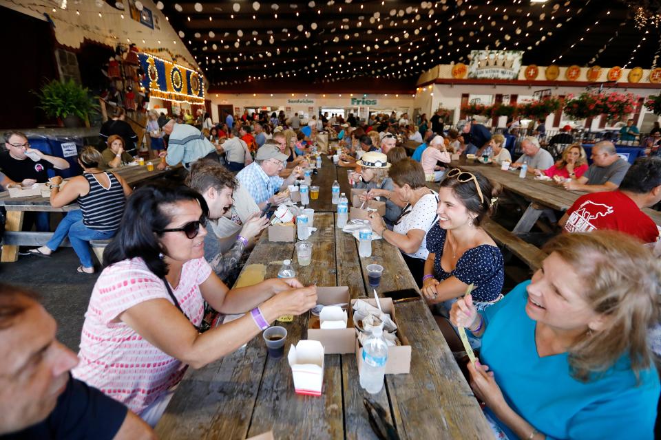 People enjoy a variety of different foods available on the first night of the 2023 Feast of the Blessed Sacrament held at Madeira Field in New Bedford.