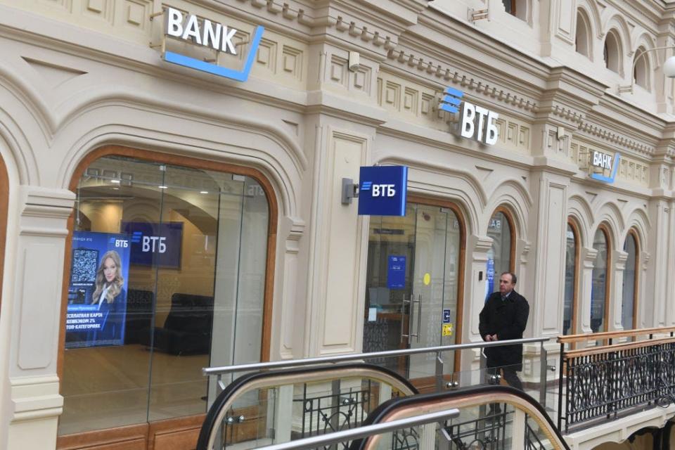 A man walks past VTB Bank at the Gum Building.