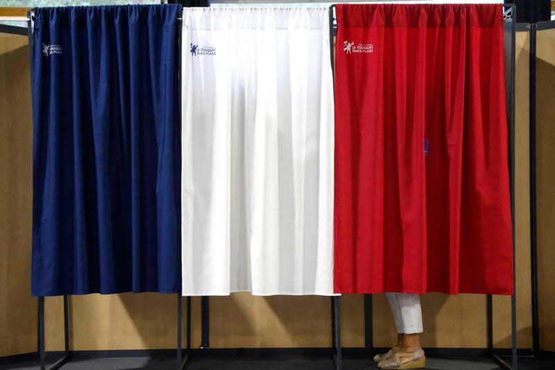 A woman casts her vote at a polling station during the second round of the French parliamentary elections. On July 7, 2024, France is holding parliamentary elections that will be decisive for the country's political future and in which the far right could become the largest party in parliament for the first time. Ludovic Marin/AFP/dpa