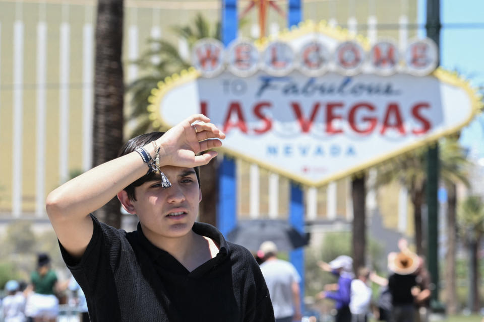 A man holds his right hand to his forehead in 120-degree heat near the Las Vegas strip on Sunday.