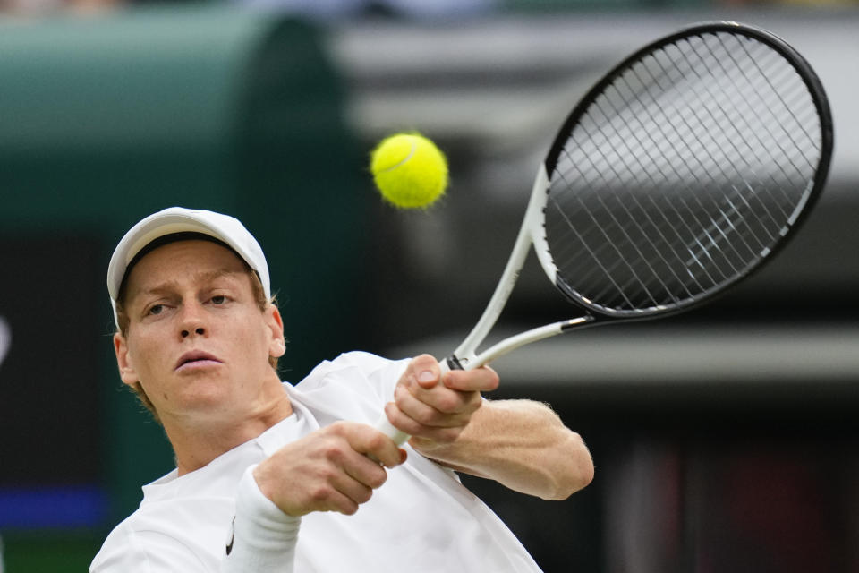 Jannik Sinner of Italy plays a backhand return to Ben Shelton of the United States during their fourth round match at the Wimbledon tennis championships in London, Sunday, July 7, 2024. (AP Photo/Kirsty Wigglesworth)