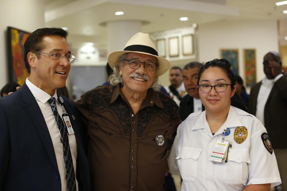 Edward James Olmos poses for a photo with University Medical Center staff with George Lopez popping out from the back.