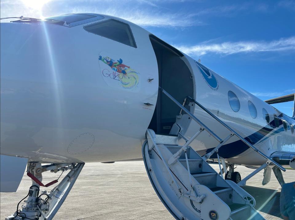 a large white jet sits on a tarmac under blue sky