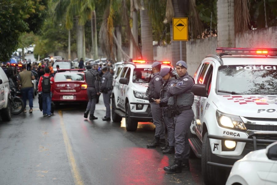 Police stand along the street leading to the gated community where a plane crashed in Vinhedo, Sao Paulo state, Brazil, Friday, Aug. 9, 2024. (AP Photo/Andre Penner)