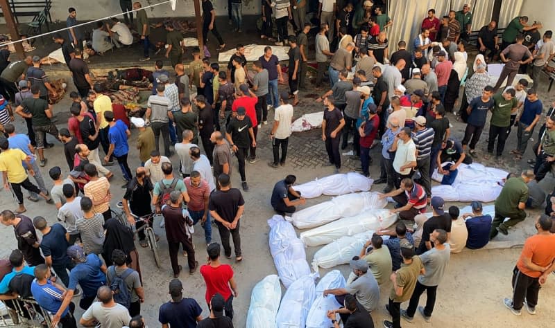 People mourn near the bodies of Palestinians who were killed in Israeli attack on the Al-Tabeen school which sheltering displaced Palestinians in Gaza City, at the al-Maamadani hospital. At least 100 people were killed and dozens more were wounded. Hadi Daoud/APA Images via ZUMA Press Wire/dpa