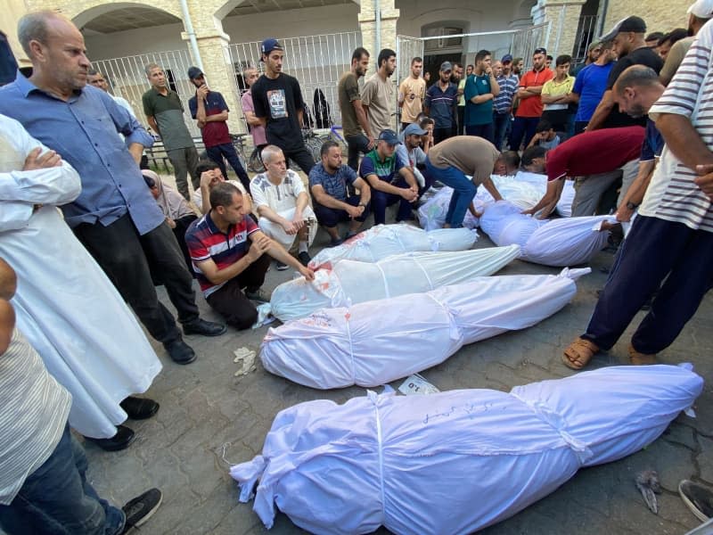 People mourn near the bodies of Palestinians who were killed in Israeli attack on the Al-Tabeen school which sheltering displaced Palestinians in Gaza City, at the al-Maamadani hospital. At least 100 people were killed and dozens more were wounded. Hadi Daoud/APA Images via ZUMA Press Wire/dpa