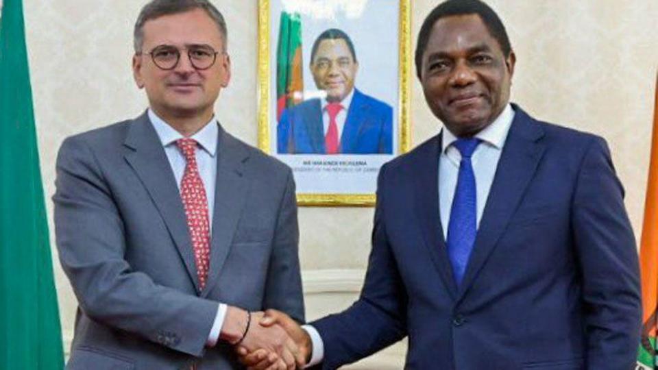 Ukrainian Foreign Minister Dmytro Kuleba (L) shakes hands with Zambia's President Hakainde Hichilema