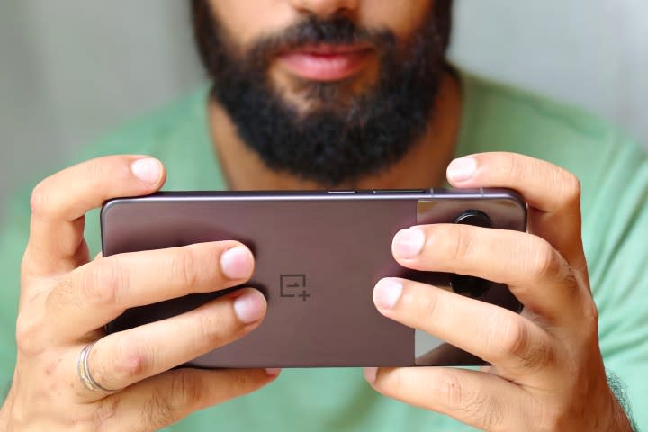 Man playing games on OnePlus Nord 4 Midnight black.