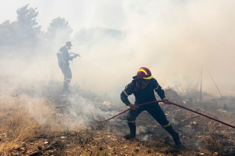 Firefighters try to extinguish pockets of embers in the blaze near Athens. Hundreds of firefighters, supported by dozens of water-dropping planes and helicopters, continued their battle against the flames of the blaze in the north of Athens this morning. Socrates Baltagiannis/dpa