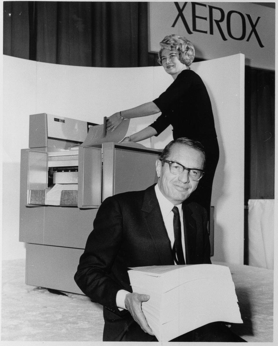 Joseph C. Wilson, President and Chief executive officer of Xerox Corp. holds 2400 copies of an original reproduced in one hour on the new xerox copier as it was introduced here in New York City at a press conference October, 1964. (AP Photo)