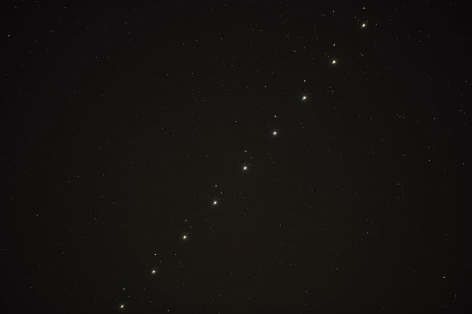 a series of nine images of jupiter and mars conjunction put together in one composition image shows the two points of light travelling up together through the sky, there are some smaller bright points of light close to Jupiter, these are some of the planet's moons.