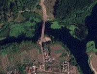 A satellite image of a strategic Russian bridge that was struck. There are black marks on the bridge.