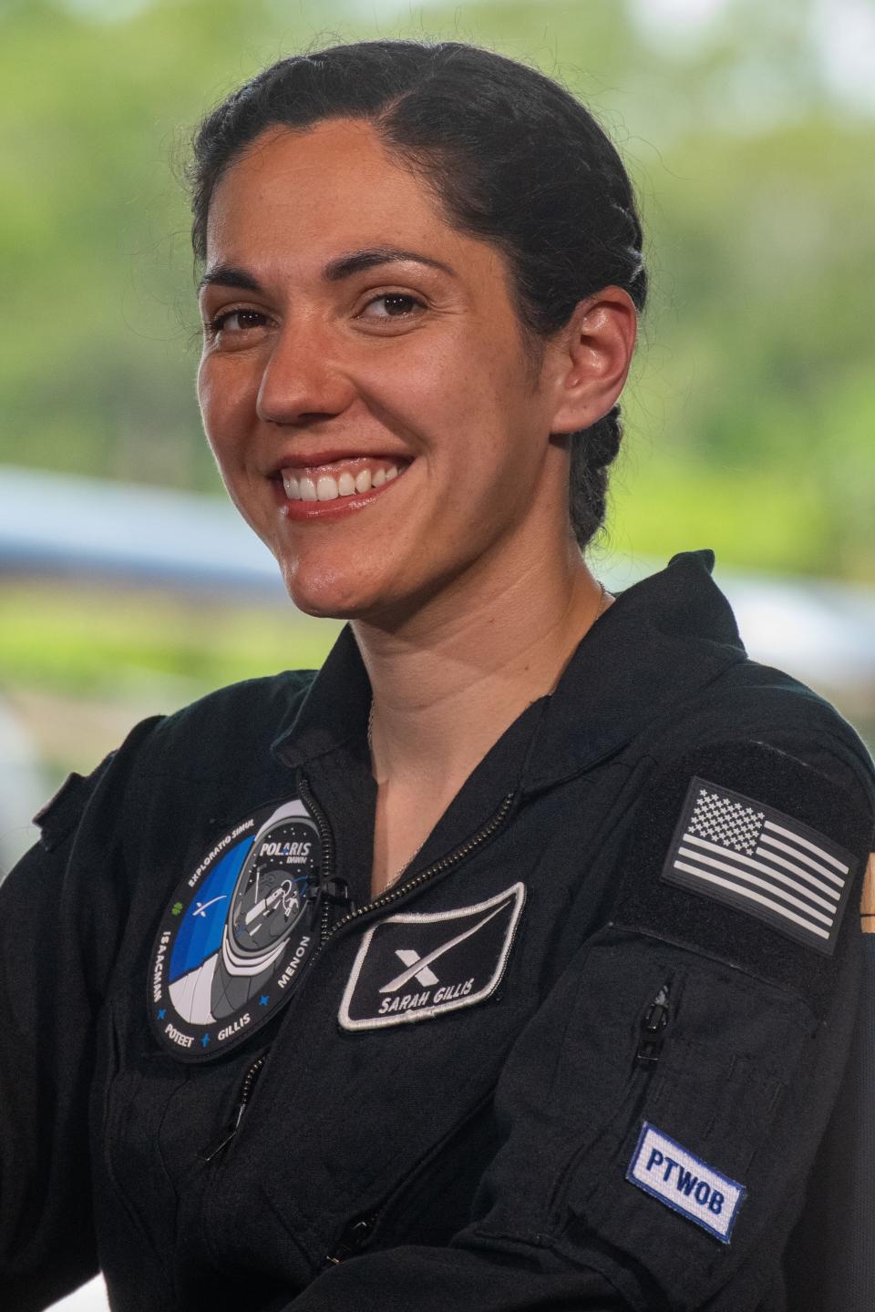 A woman with dark hair is smiling.