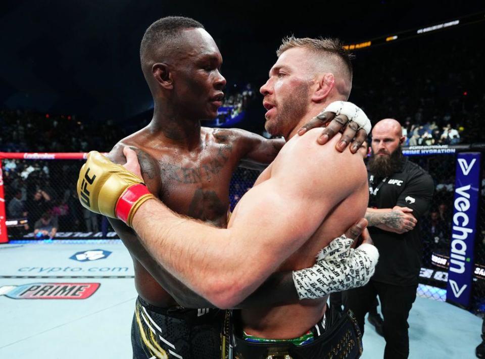 Dricus Du Plessis of South Africa and Israel Adesanya of Nigeria embrace and talk in the ring.