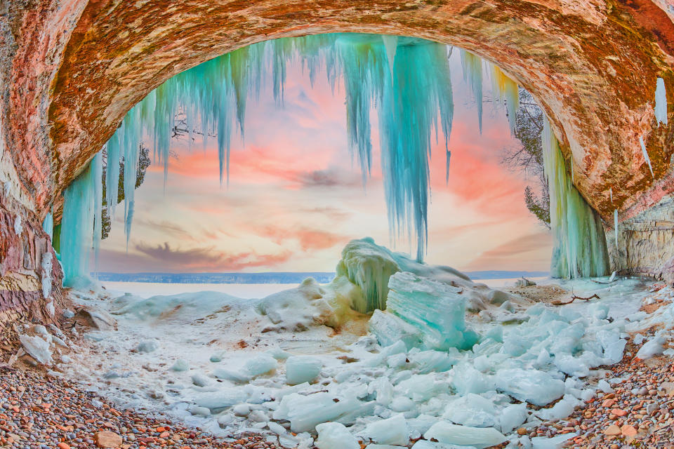 Image of Stunning ice cave on Lake Michigan during sunrise with large blue icicles