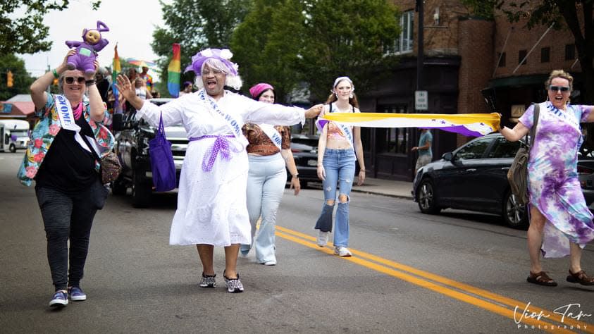 Activist Ms. Darryl Demure (purple hat) has hosted and produced "Harper's Bazzaroworld Presents The Ms. Demure Show" on DATV in Dayton, Ohio, for more than 25 years. It is the nation's oldest LGBTQ+ public access variety talk show.