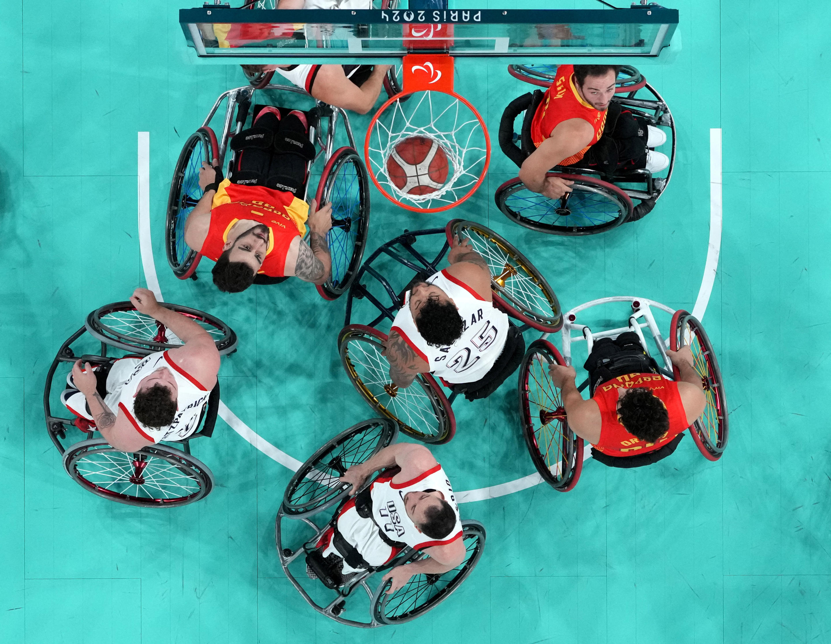 Wheelchair competitors shown on a basketball court.