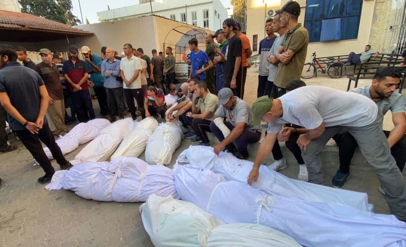 People mourn near the bodies of Palestinians who were killed in Israeli attack on the Al-Tabeen school which sheltering displaced Palestinians in Gaza City, at the al-Maamadani hospital. At least 100 people were killed and dozens more were wounded. Hadi Daoud/APA Images via ZUMA Press Wire/dpa