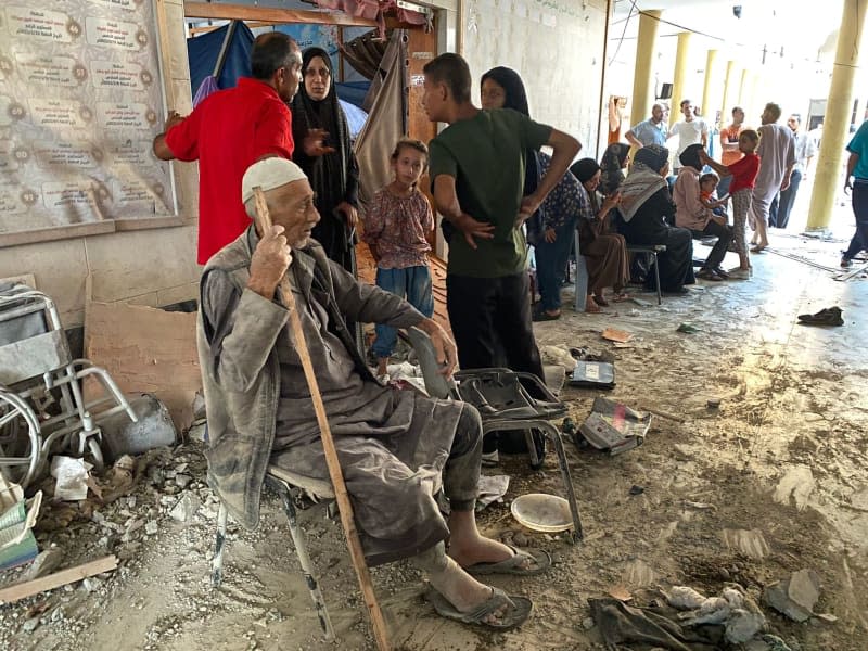 People sit following an Israeli strike that killed at least 100 people on a school sheltering displaced Palestinians in Gaza City. Khaled Daoud/APA Images via ZUMA Press Wire/dpa