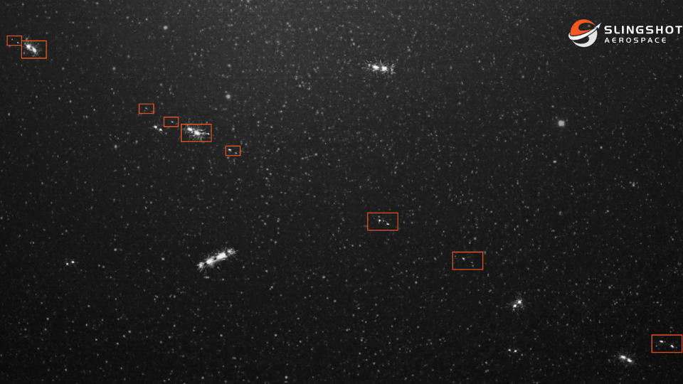  Photo showing several bright objects outlined by red boxes, standing out against a starry black sky. 