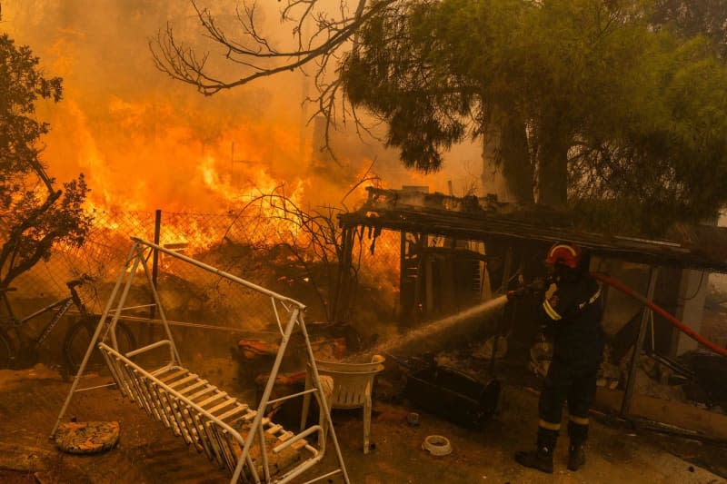 A firefighter extinguishes a large fire, just a few kilometers northeast of Athens. EU member states are sending aid to Greece to help emergency services in battling the country's biggest wildfire of the year on Monday, with multiple flash points burning across some 200 square kilometres of woodland north-east of the capital Athens. Socrates Baltagiannis/dpa