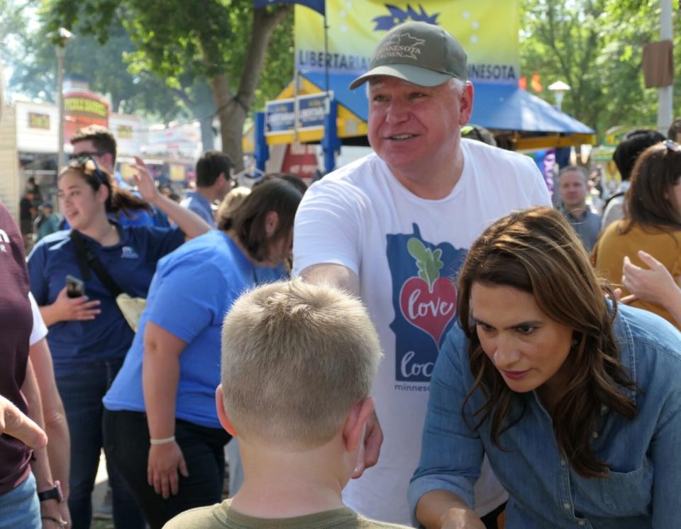 Gov. Tim Walz and Lt. Gov. Peggy Flanagan complimenting a child at fair about his “Smokey the Bear” shirt. (Baylor Spears/Minnesota Reformer)