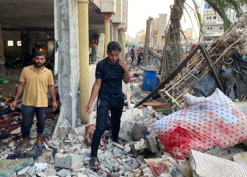 People inspect damages following an Israeli strike that killed at least 100 people on a school sheltering displaced Palestinians in Gaza City. Khaled Daoud/APA Images via ZUMA Press Wire/dpa