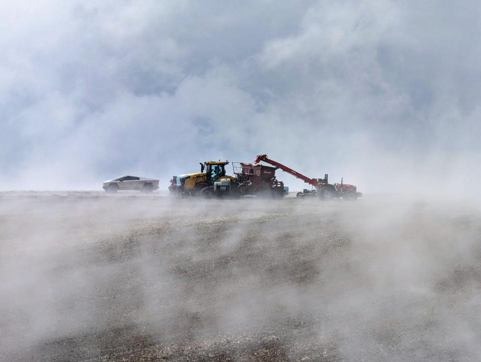 Braden Smith planting potatoes in his Tesla Cybertruck while surrounded by fog.