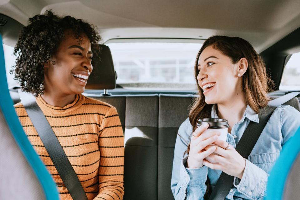 Two women in the back of a ride-sharing vehicle.