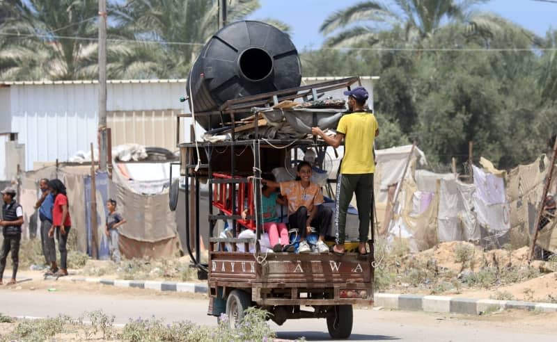 Palestinians carry their belongings as they flee Deir el-Balah in the central Gaza Strip. The Israeli military on Friday called on civilians in southern and central Gaza to flee ahead of a new military operation. Omar Ashtawy/APA Images via ZUMA Press Wire/dpa