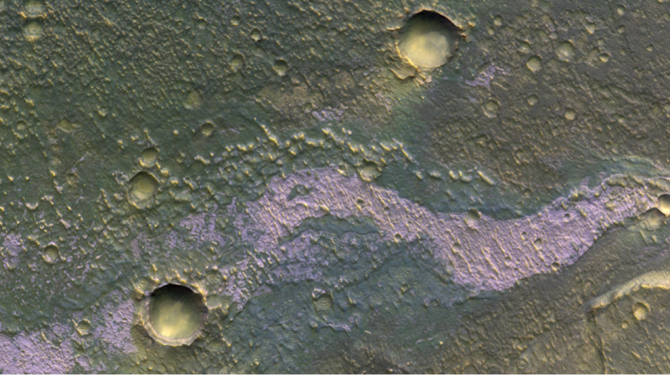  A purple streak across a rusty red landscape pockmarked with craters. 