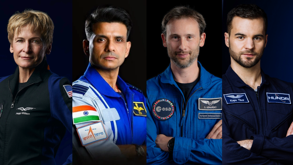  Four people in flight suits pose for a portrait. 