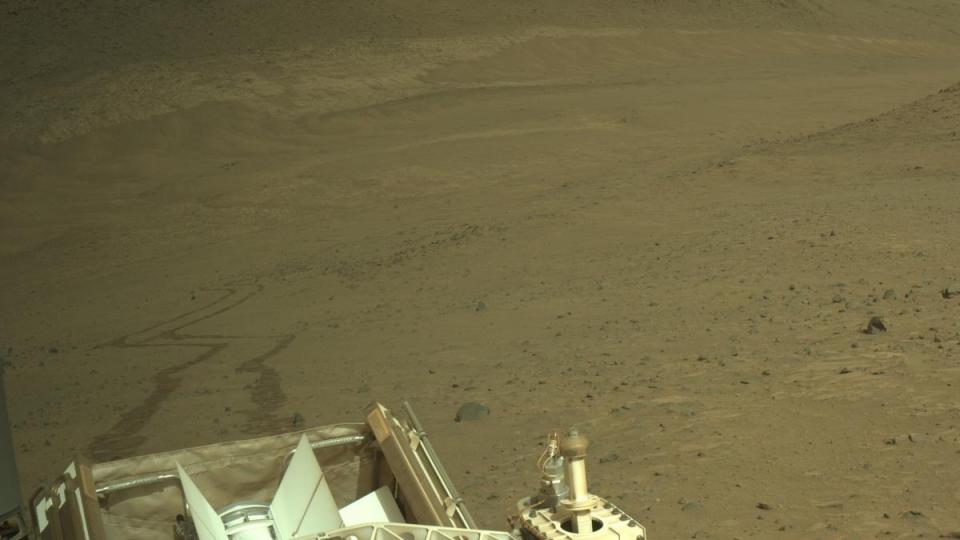  A brownish landscape with a metal structure in the foreground. 