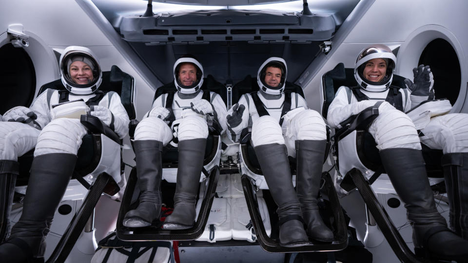  The four astronauts of SpaceX's Polaris Dawn private mission pose in black and white spacesuits inside their Dragon capsule. 