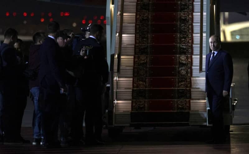 Russian President Vladimir Putin (R) waits for the prisoners released following the swap deal at Vnukovo International Airport in Moscow. -/KREMLIN/dpa