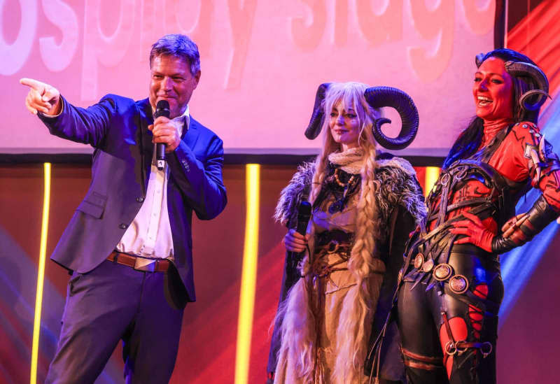 Robert Habeck (L), German Minister for Economic Affairs and Climate Protection, talks to cosplayers during his tour of Gamescom. The Gamescom computer and video games trade fair takes place in Cologne from August 21-25, 2024. Oliver Berg/dpa