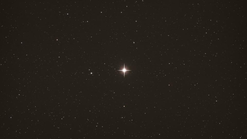  A bright star in the center of the screen against the dark background of space. 