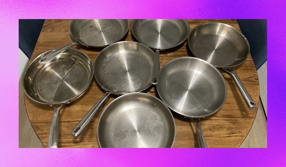 7 stainless steel pans on wood table